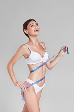 Beyaz iç çamaşırlı, ölçü bandıyla mükemmel kadın vücudu..