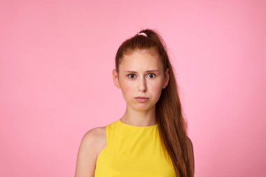 Pembe arka planda tatminsiz genç kız.
