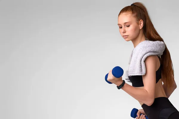 Mujer en ropa deportiva negra haciendo ejercicio con pesas — Foto de Stock