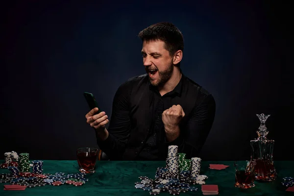 Homem jogador de casino barbudo jogando poker na mesa verde — Fotografia de Stock