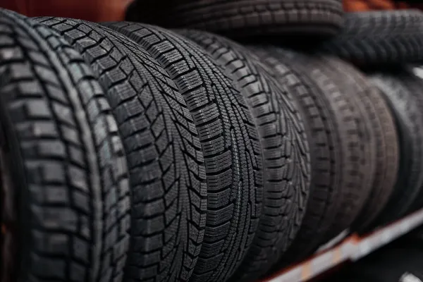 Neumáticos de coche en un estante en una tienda de automóviles —  Fotos de Stock