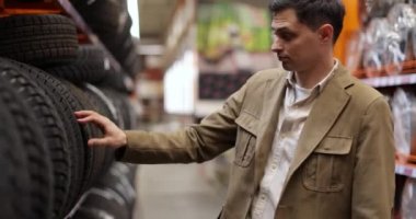 Erkek müşteri yeni lastik süpermarketi seçiyor.
