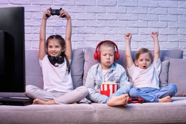 Oyun konsoluyla oyun oynayan çocuklar