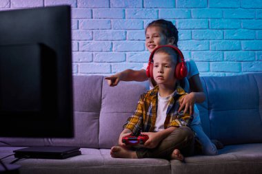 Oyun konsoluyla oyun oynayan çocuklar