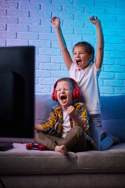 Oyun konsoluyla oyun oynayan çocuklar