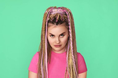 Yeşil arka planda rastalı, tatminsiz kadın.