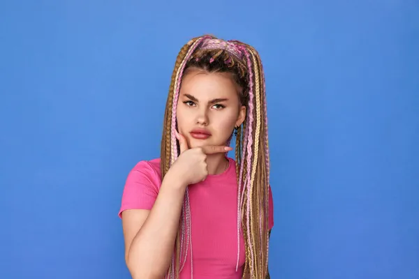 Missnöjd kvinna med dreadlocks på blå bakgrund. — Stockfoto