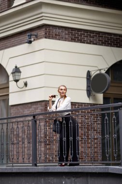 Güneşli bir günde şehirde güneş gözlüklü bir kadın.