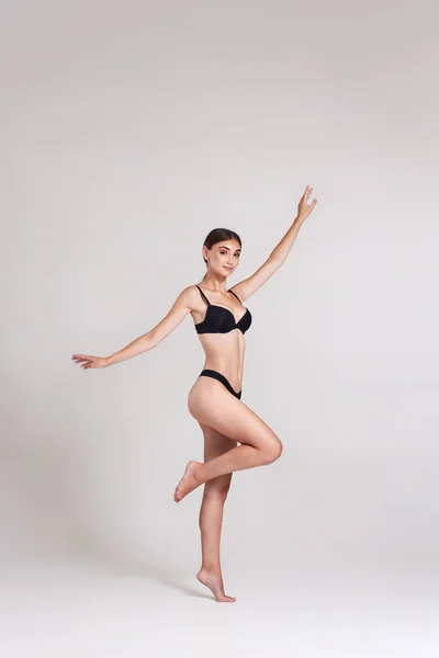 Красива жінка з ідеальним тілом в чорній білизні стрибає — стокове фото