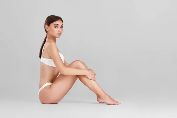 Жінка з ідеальним тілом і ногами в білій білизні — стокове фото