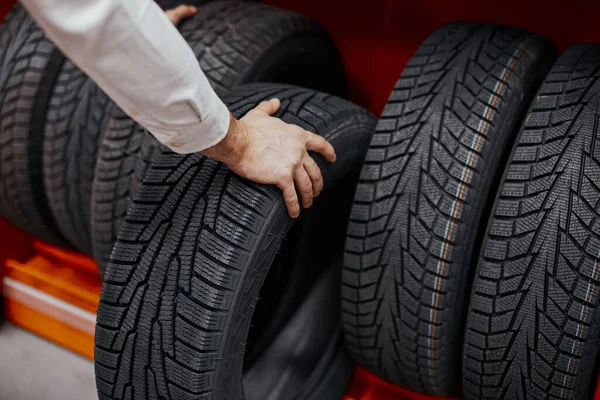 Primer plano de una mano de hombre con neumáticos de coche —  Fotos de Stock