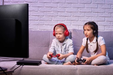 Oyun konsoluyla oyun oynayan çocuklar