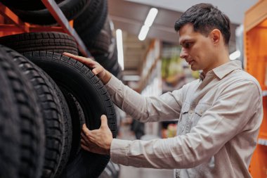 erkek müşteri süpermarkette yeni lastik seçimi .
