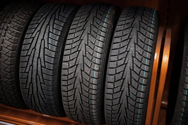 Un montón de neumáticos de coche en un estante en una tienda de automóviles —  Fotos de Stock
