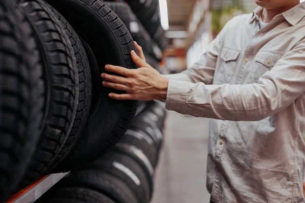 Manliga kunden väljer nya däck i snabbköpet . — Stockfoto