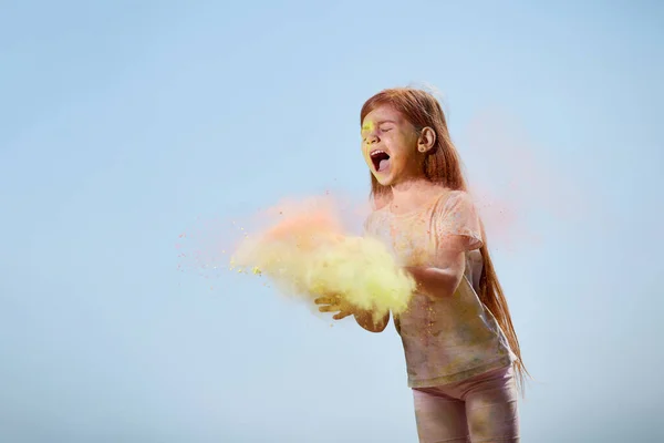 Счастливая маленькая девочка бросает яркие игрушки — стоковое фото