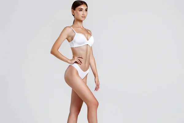 Smal kvinna med perfekt kropp i vita underkläder — Stockfoto