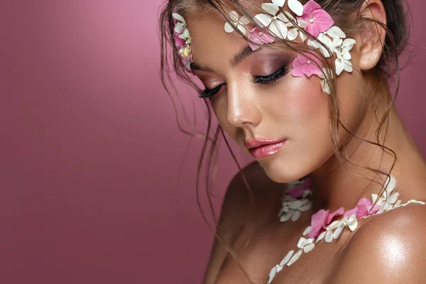 Frumoasa femeie caucaziană cu flori pe fundal roz. — Fotografie, imagine de stoc