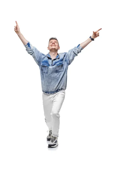 Человек в джинсовой куртке празднует успех с поднятыми руками — стоковое фото