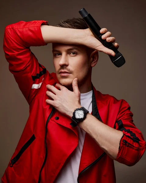 Bonito masculino cantor no vermelho jaqueta com microfone — Fotografia de Stock
