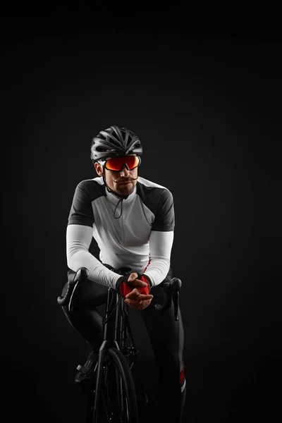 Männlicher Radfahrer mit Rennrad auf schwarzem Hintergrund — Stockfoto