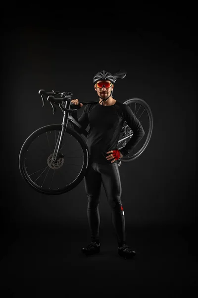 Männlicher Radfahrer mit Rennrad auf schwarzem Hintergrund — Stockfoto