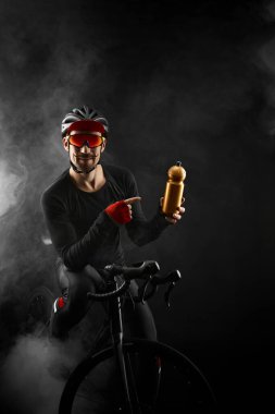 Siyah arka planda yol bisikleti olan erkek bisikletçi