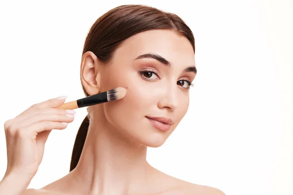 Vrouw aanbrengen foundation op de huid met make-up borstel — Stockfoto