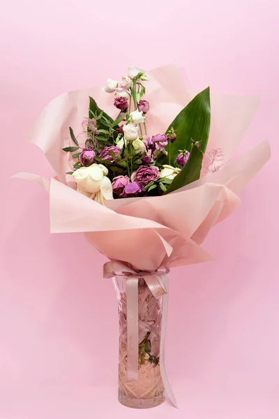 Vase de fleurs mourantes sur fond rose — Photo