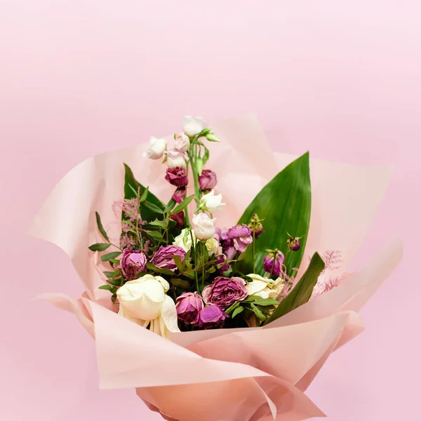 Bouquet de fleurs mourantes sur fond rose — Photo