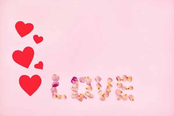 Word love made of pink rose petals on pink background. — Stock Photo, Image