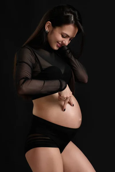 Hermosa mujer embarazada en vestido sosteniendo su vientre — Foto de Stock