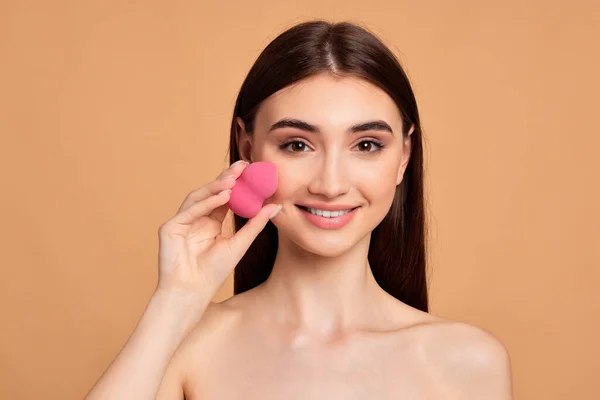 Jovem posando com esponjas cosméticas rosa — Fotografia de Stock