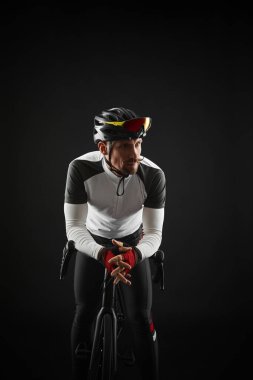 Siyah arka planda yol bisikleti olan erkek bisikletçi