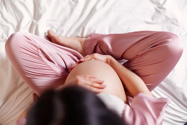 Kobieta w ciąży trzymając ręce na brzuchu — Zdjęcie stockowe