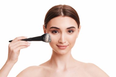 Makyaj fırçasıyla pudra süren kadın