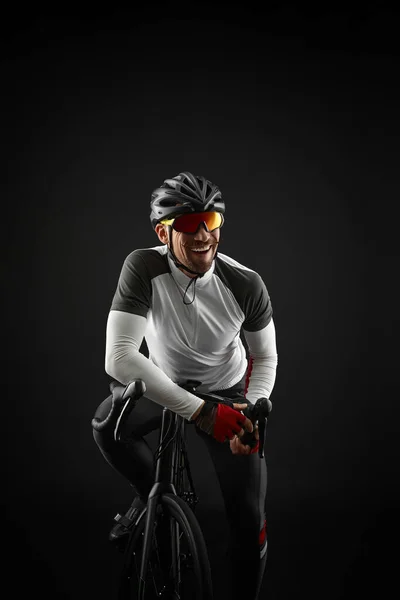 Ciclista di sesso maschile con bicicletta da strada su sfondo nero — Foto Stock