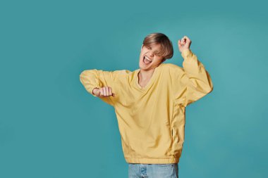 Sarı elbiseli genç adam dans ediyor.