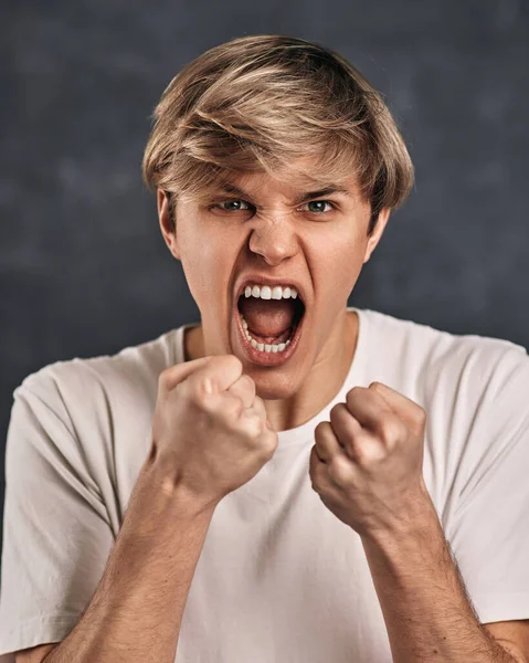 Jovem cara em t-shirt de pé com gesto de boxe — Fotografia de Stock