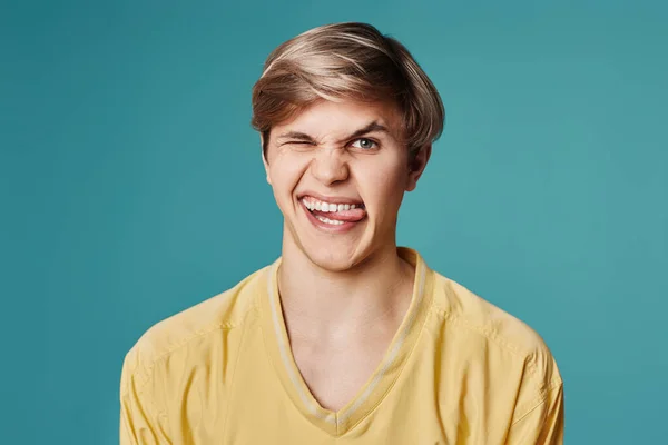 Handsome guy grimacing on a dark gray background — Fotografia de Stock