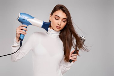 Çekici, neşeli, kuru, sağlıklı saçları olan bir kadın.