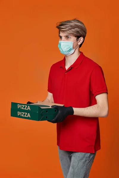 Repartidor de pizza en camiseta roja con cajas de cartón — Foto de Stock