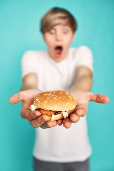 Very hungry young man holding tasty hamburger — Foto de Stock