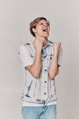 Kot giyen yakışıklı adam zafer işareti yapıyor.