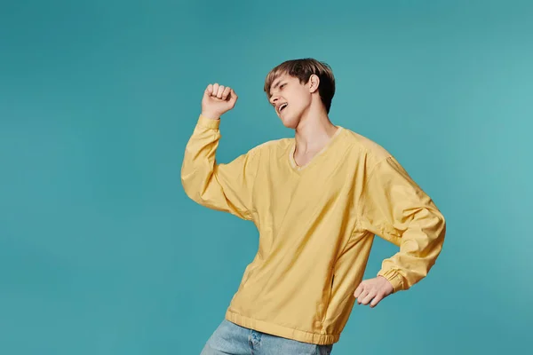 Young man in casual yellow clothes dancing — Stok fotoğraf