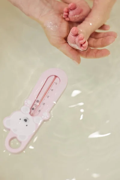 Babyfötter i badkaret. Baby hudvård. — Stockfoto