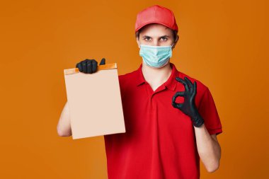 Kırmızı maskeli teslimatçı eleman, boş karton kutu.