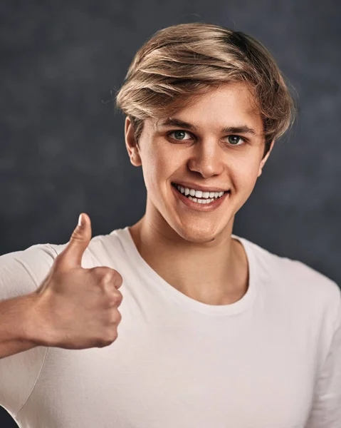 Young smiling handsome guy showing Ok gesture — ストック写真