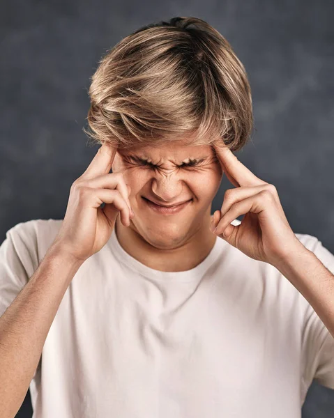 young handsome guy thinking on gray background.