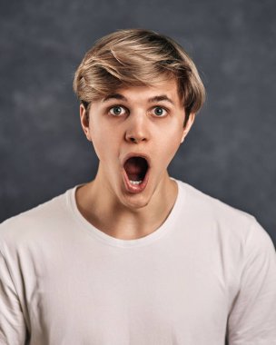 Gri arka planda genç ve yakışıklı bir adam..